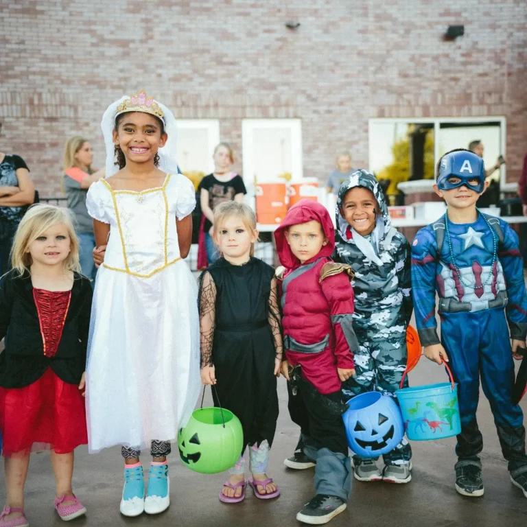 Respekt, Ehrlichkeit und Empathie: Die wichtigsten Werte für Kinder Sechs Kinder in Kostümen, die Süßigkeiten sammeln, lächeln vor einer Kulisse.